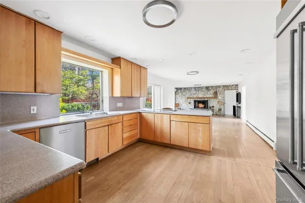 a white kitchen with wooden floor and stainless steel appliances