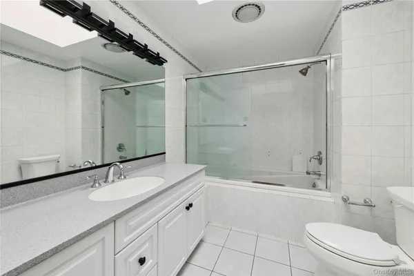a bathroom with a granite countertop sink a toilet and shower