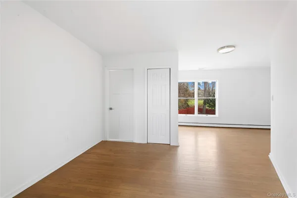a view of a room with wooden floor and window