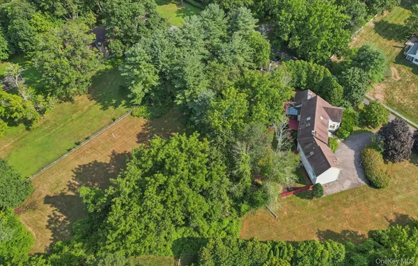 an aerial view of a house with a yard and large tree
