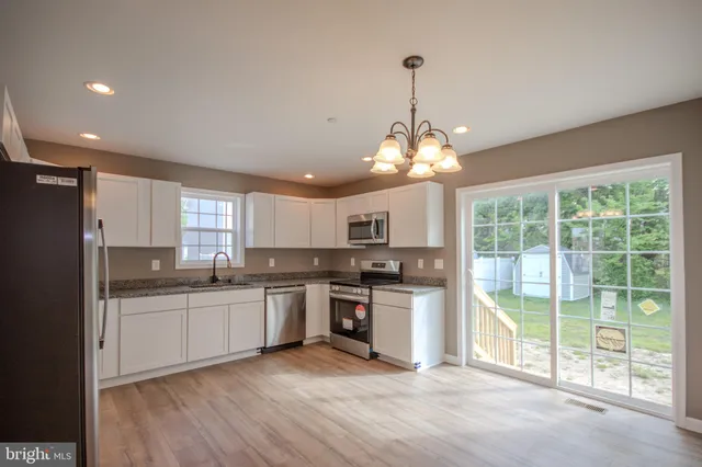 a kitchen with stainless steel appliances granite countertop a stove and cabinets