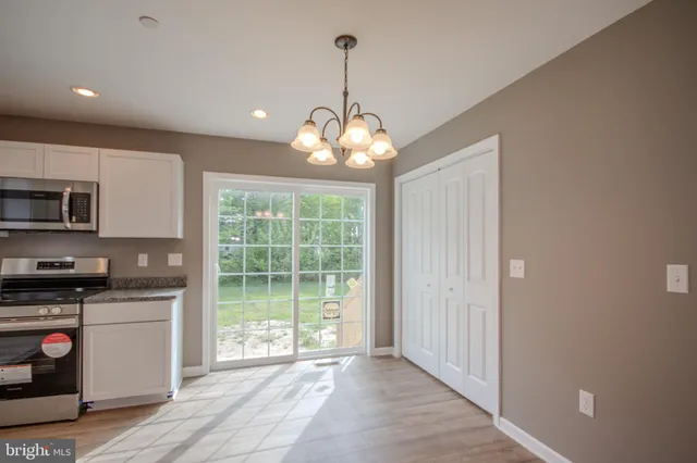 a kitchen that has a lot of cabinets and wooden floor