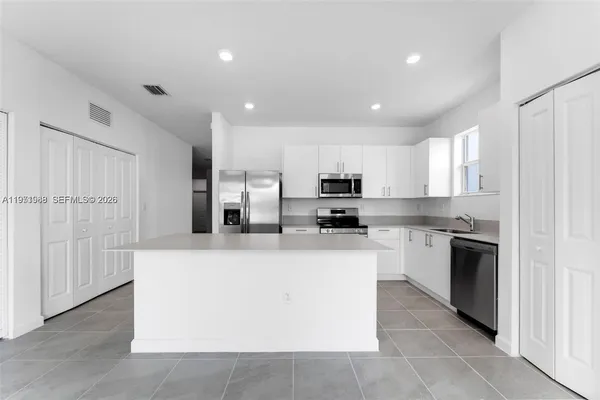 a large kitchen with stainless steel appliances lots of counter top space and cabinets