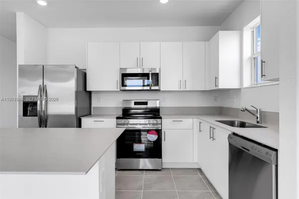 a kitchen with cabinets and stainless steel appliances