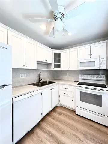 a kitchen with stainless steel appliances white cabinets a sink and dishwasher