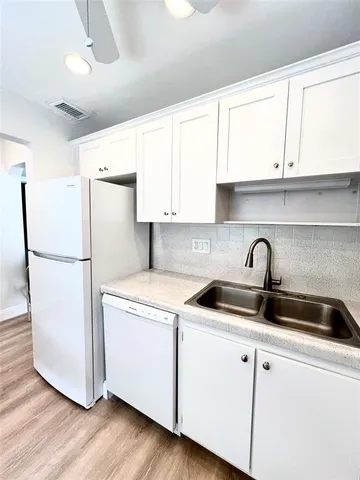 a kitchen with a refrigerator sink and cabinets