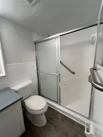a white toilet sitting next to a shower