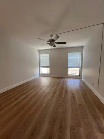 a view of a livingroom with wooden floor and a ceiling fan