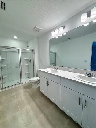 a spacious bathroom with a double vanity sink mirror and toilet
