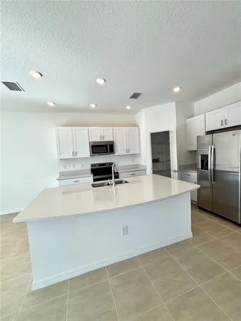 a kitchen with stainless steel appliances a refrigerator sink and microwave