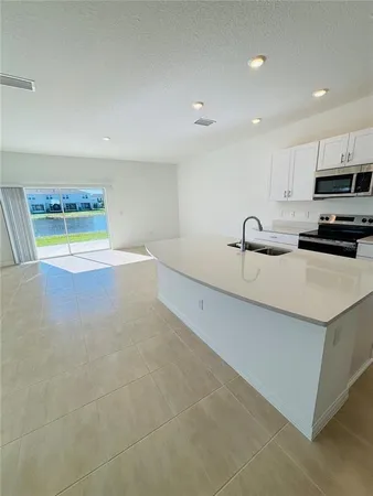 a view of a kitchen with a sink and a refrigerator