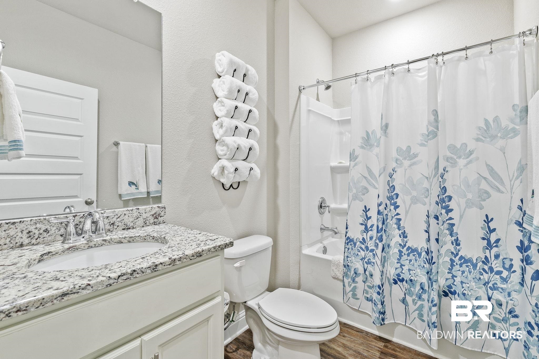 1319 Kairos Loop Foley, AL 36535 - Photo 38 of 64 Full bathroom featuring toilet, vanity, shower / tub combo, and hardwood / wood-style flooring