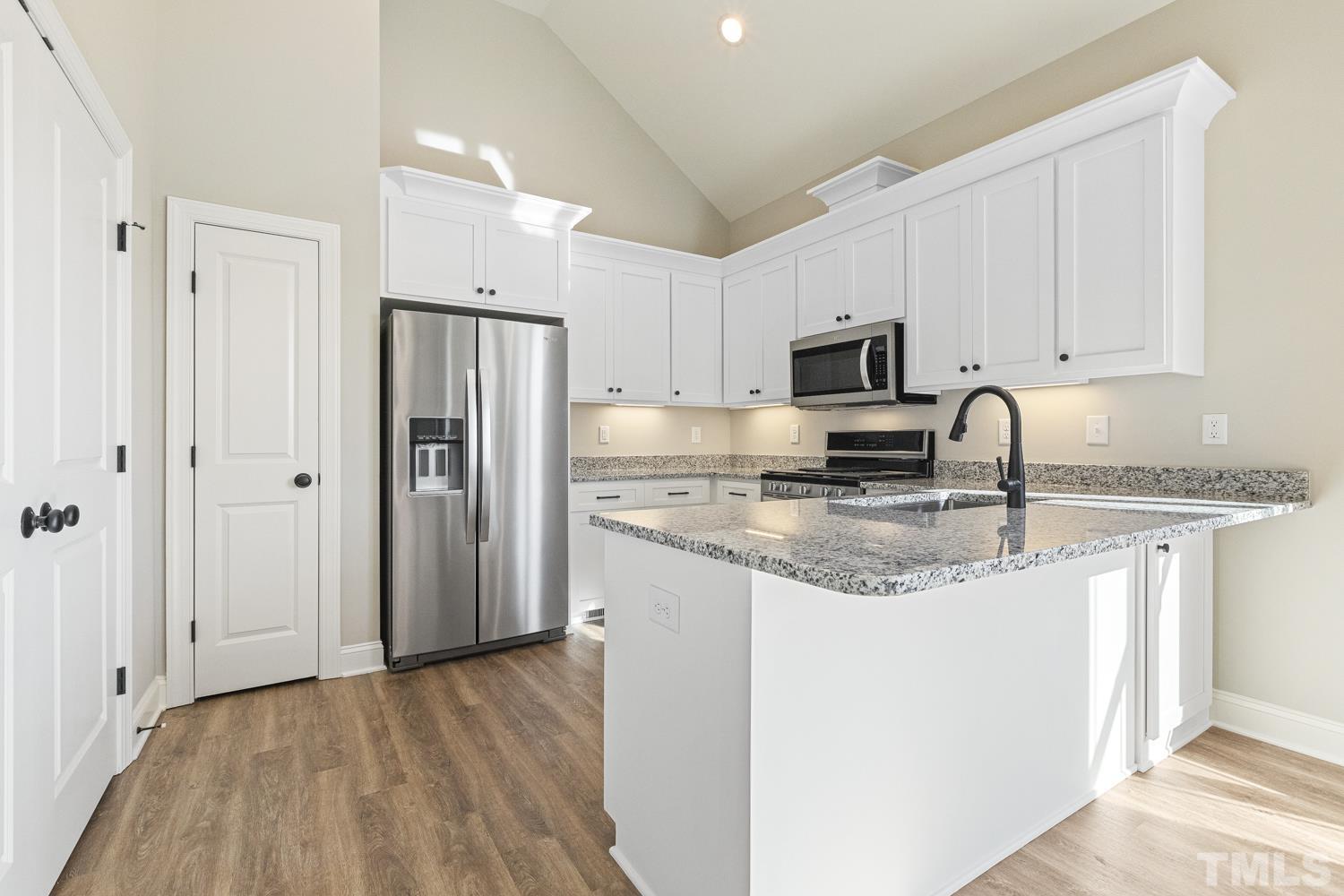 1004 Butler Drive Erwin, NC 28339 - Photo 16 of 38 a kitchen with granite countertop a refrigerator and a stove top oven