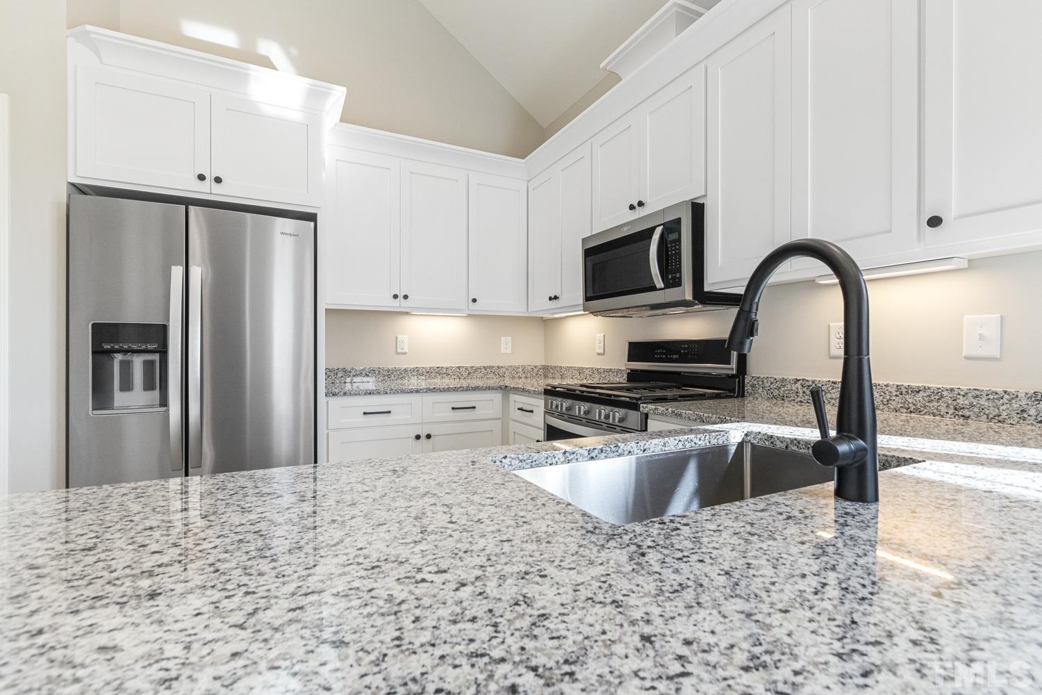 1004 Butler Drive Erwin, NC 28339 - Photo 17 of 38 a kitchen with granite countertop a refrigerator and a stove top oven