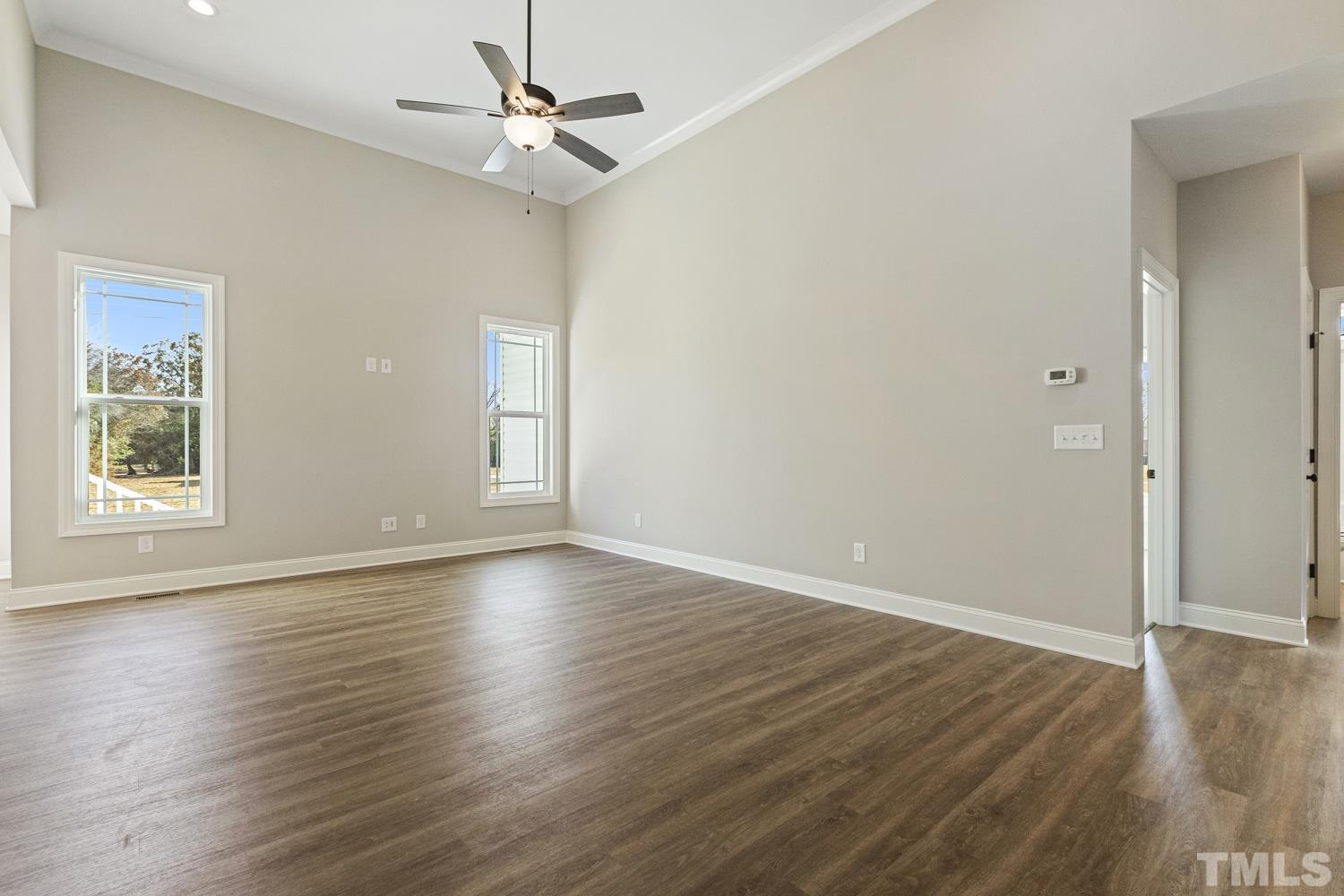 1004 Butler Drive Erwin, NC 28339 - Photo 8 of 38 an empty room with wooden floor chandelier fan and windows
