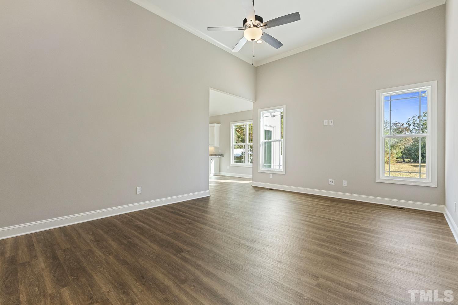 1004 Butler Drive Erwin, NC 28339 - Photo 9 of 38 an empty room with wooden floor chandelier fan and windows