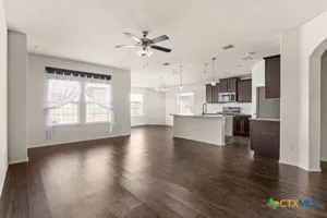 a view of an empty room with kitchen appliances and a window