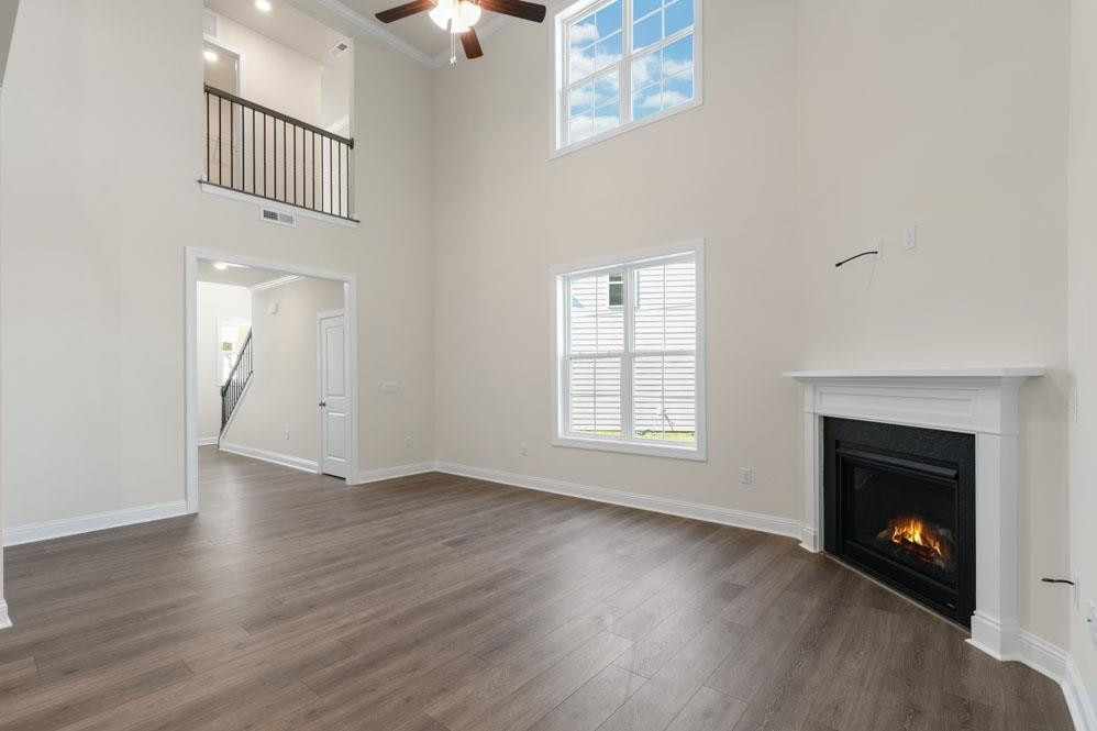 5129 Lizard Tail Lane Raleigh, NC 27603 - Photo 14 of 49 an empty room with wooden floor a fireplace and windows