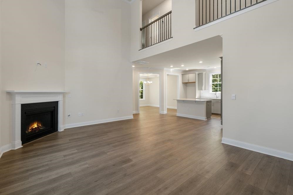 5129 Lizard Tail Lane Raleigh, NC 27603 - Photo 17 of 49 a view of an empty room with wooden floor and a kitchen