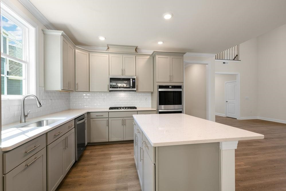 5129 Lizard Tail Lane Raleigh, NC 27603 - Photo 18 of 49 a kitchen with kitchen island a sink stainless steel appliances and white cabinets