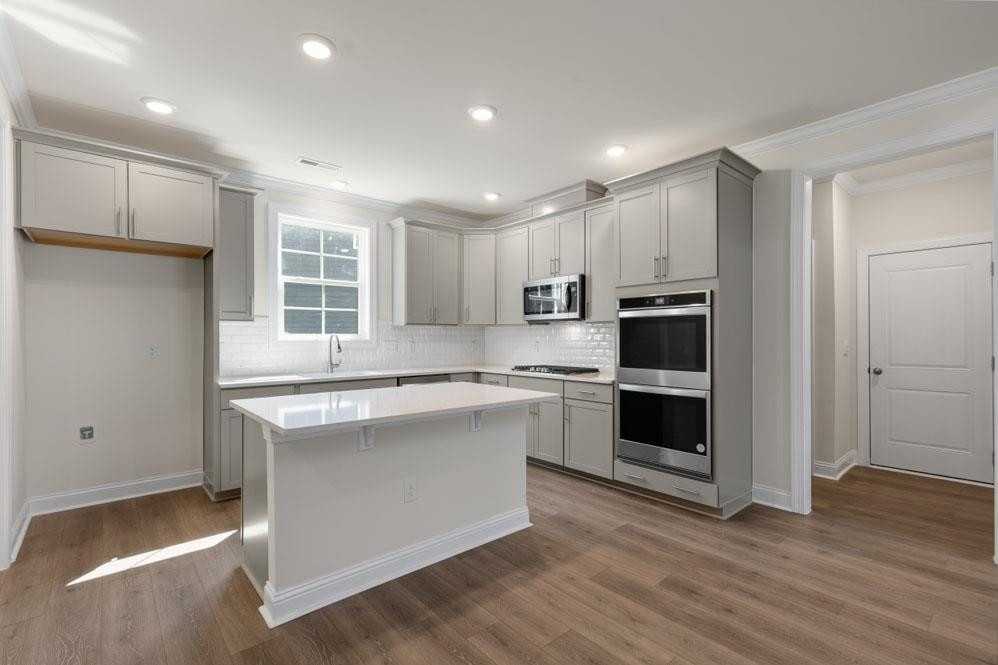 5129 Lizard Tail Lane Raleigh, NC 27603 - Photo 23 of 49 a kitchen with stainless steel appliances granite countertop a stove a sink and a refrigerator
