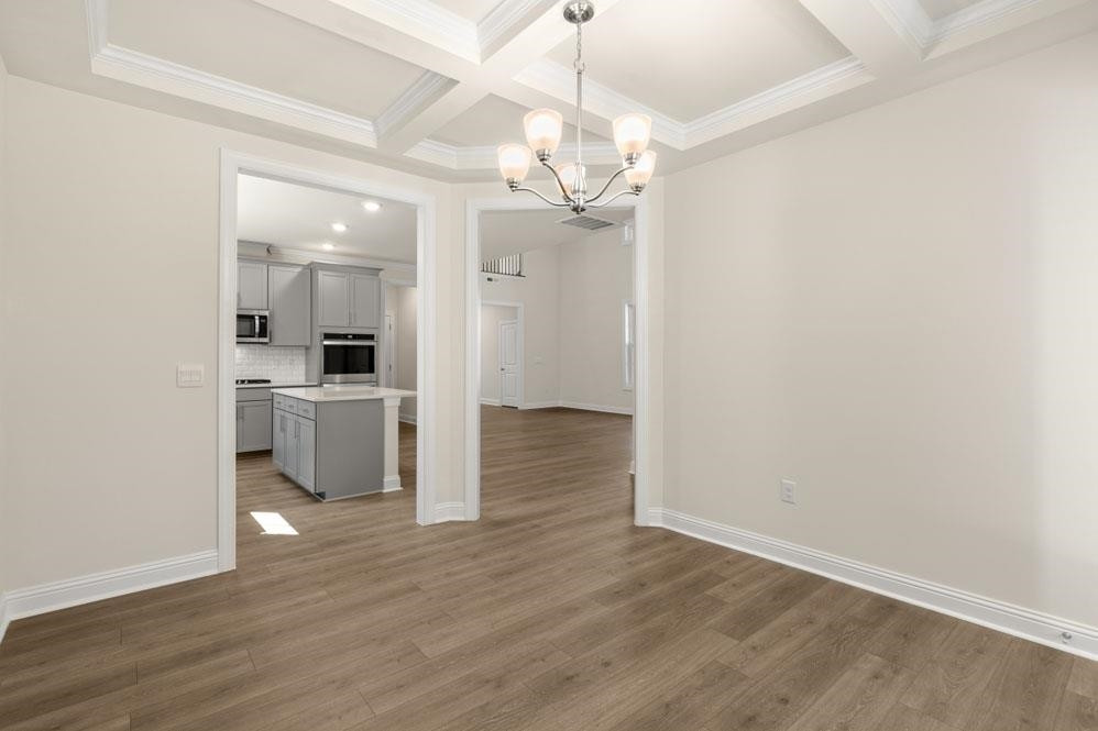 5129 Lizard Tail Lane Raleigh, NC 27603 - Photo 32 of 49 a view of a hallway with wooden floor and a kitchen