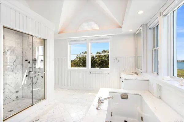 a bathroom with a bathtub sink and mirror