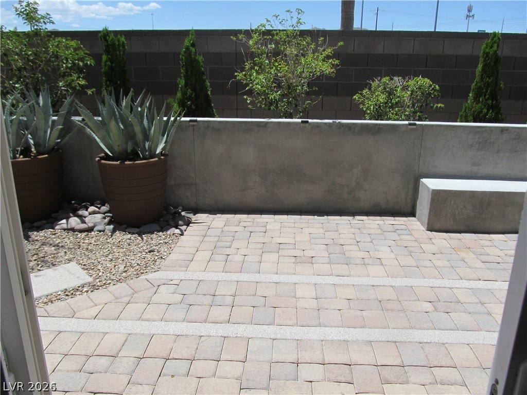 2157 Rio Rancho Pointe Place Henderson, NV 89002 - Photo 10 of 24 An inviting paver patio provides a low-maintenance outdoor living space, complete with a built-in concrete bench.