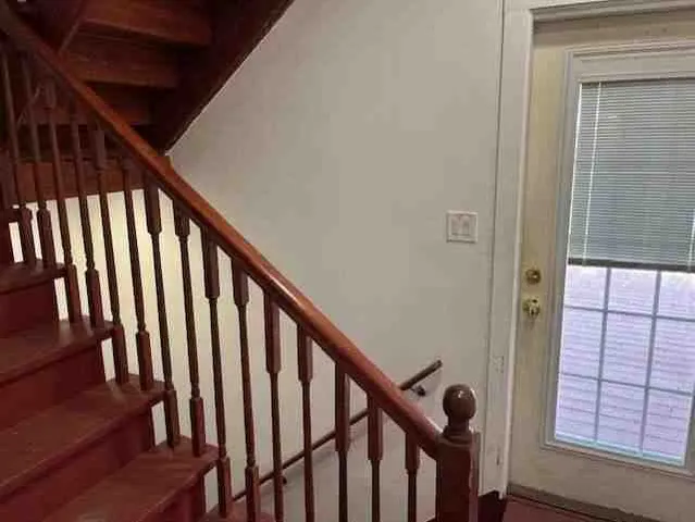 a view of staircase with railing and white walls