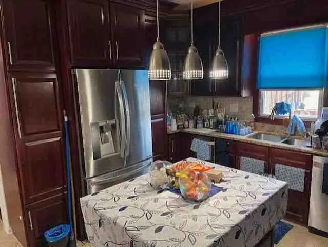 a kitchen with stainless steel appliances wooden floor sink and refrigerator