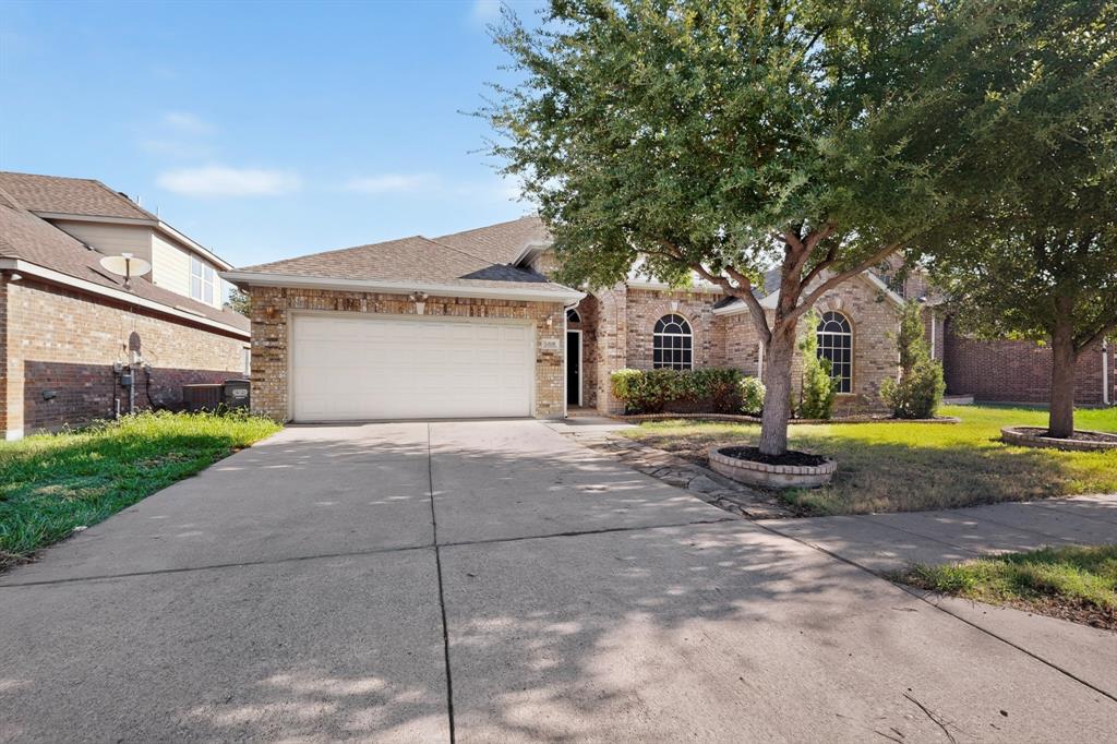 14908 Riverside Drive Little Elm, TX 75068 - Photo 4 of 40 Brick exterior with arched windows, an attached two-car garage, and a concrete driveway