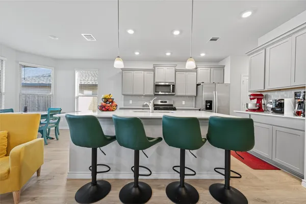 a kitchen with granite countertop a dining table chairs sink and cabinets