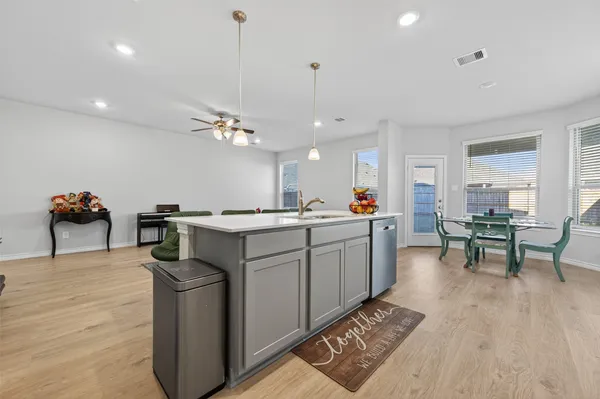 a kitchen with a sink cabinets and wooden floor