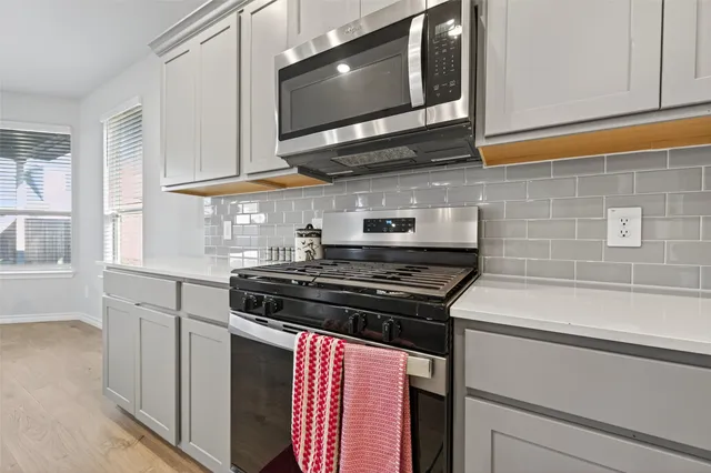 a kitchen with stainless steel appliances granite countertop a stove and a microwave