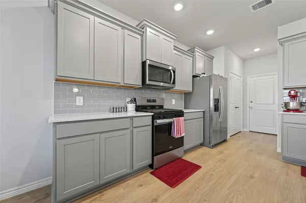 a kitchen with stainless steel appliances granite countertop a refrigerator sink and microwave