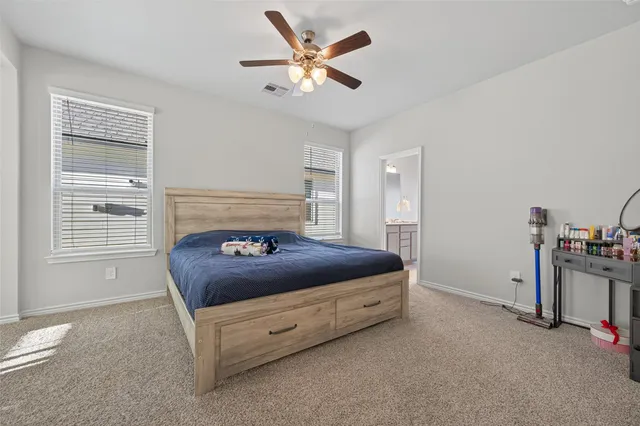 a bedroom with a bed and a ceiling fan