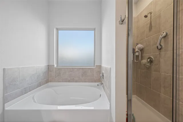 a white bath tub sitting next to a shower