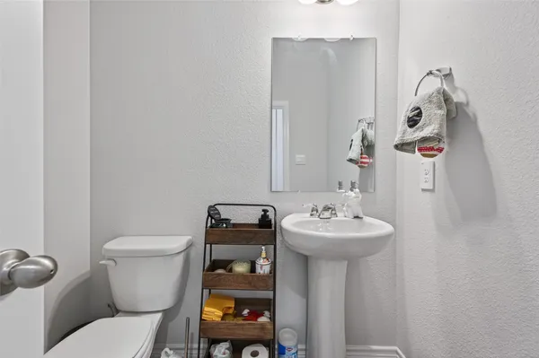 a bathroom with a sink toilet and a mirror