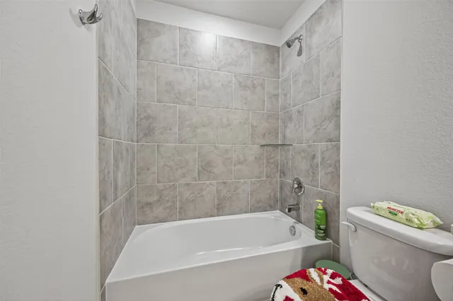 a white bath tub sitting next to a white toilet and sink