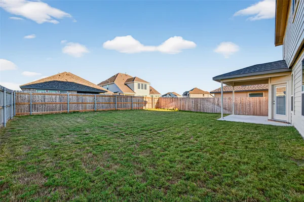 a view of a house with a small yard and wooden fence