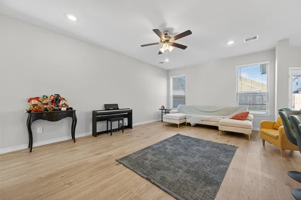 a living room with furniture and a wooden floor