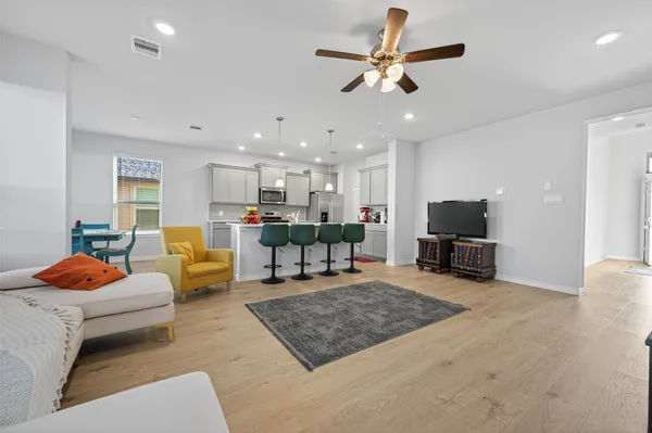 a living room with furniture and a flat screen tv with kitchen view