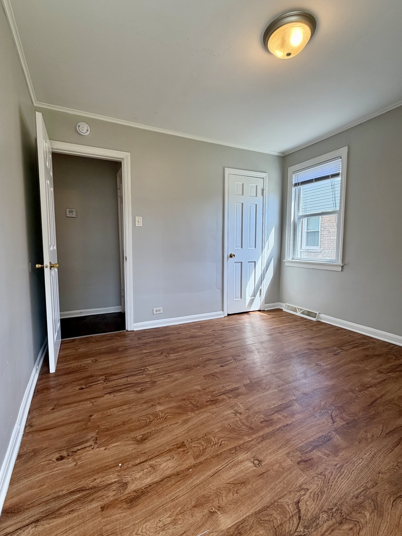 17826 School Street Lansing, IL 60438 - Photo 11 of 23 a view of an empty room with wooden floor and a window