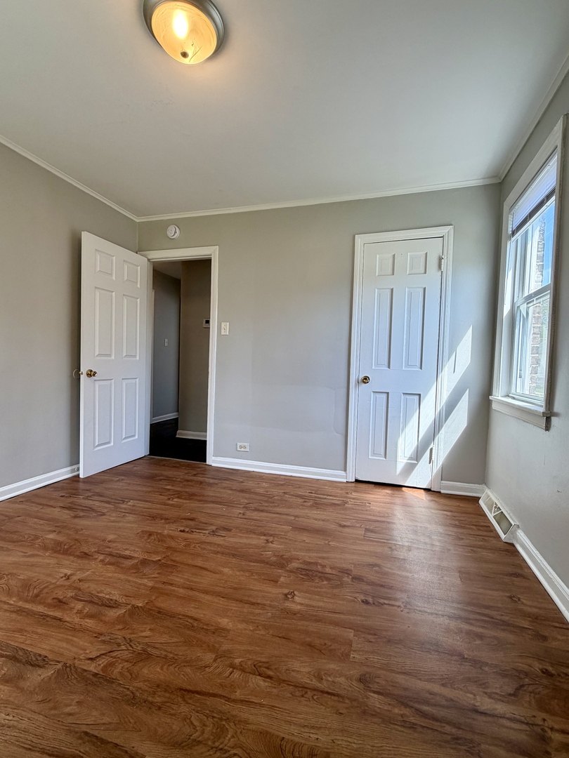 17826 School Street Lansing, IL 60438 - Photo 12 of 23 a view of an empty room with wooden floor and a window