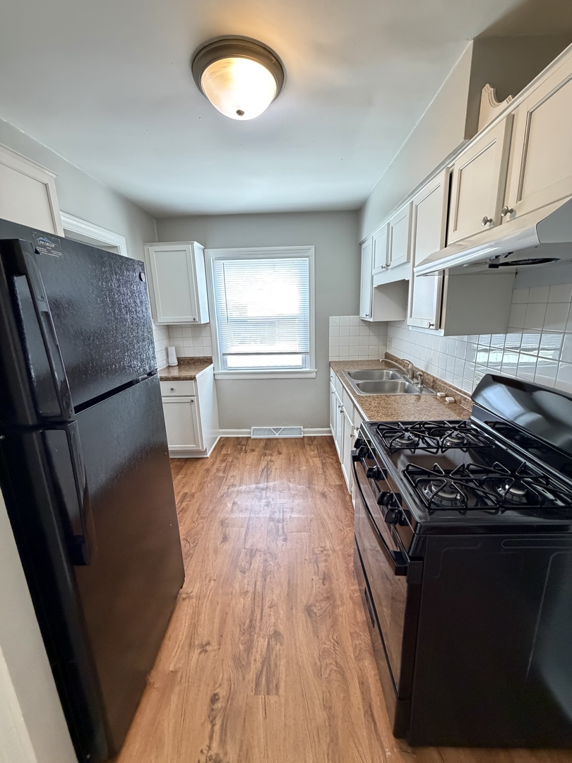 17826 School Street Lansing, IL 60438 - Photo 13 of 23 a kitchen with granite countertop a stove and a refrigerator