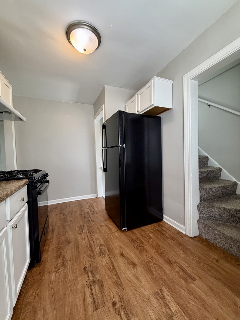 17826 School Street Lansing, IL 60438 - Photo 14 of 23 a view of a kitchen with wooden floor and a refrigerator