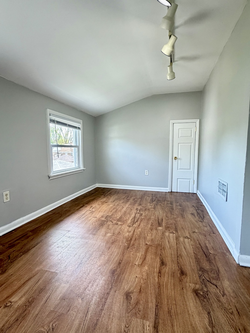 17826 School Street Lansing, IL 60438 - Photo 16 of 23 a view of empty room with wooden floor and fan