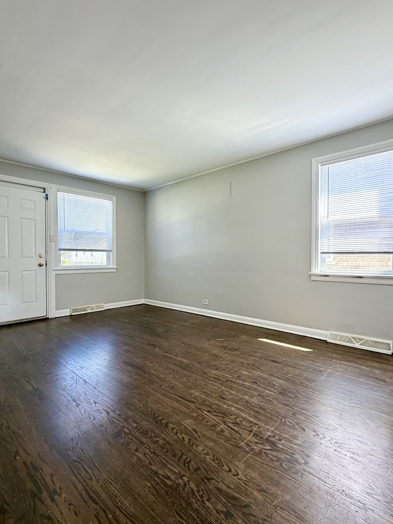 17826 School Street Lansing, IL 60438 - Photo 4 of 23 an empty room with wooden floor and windows