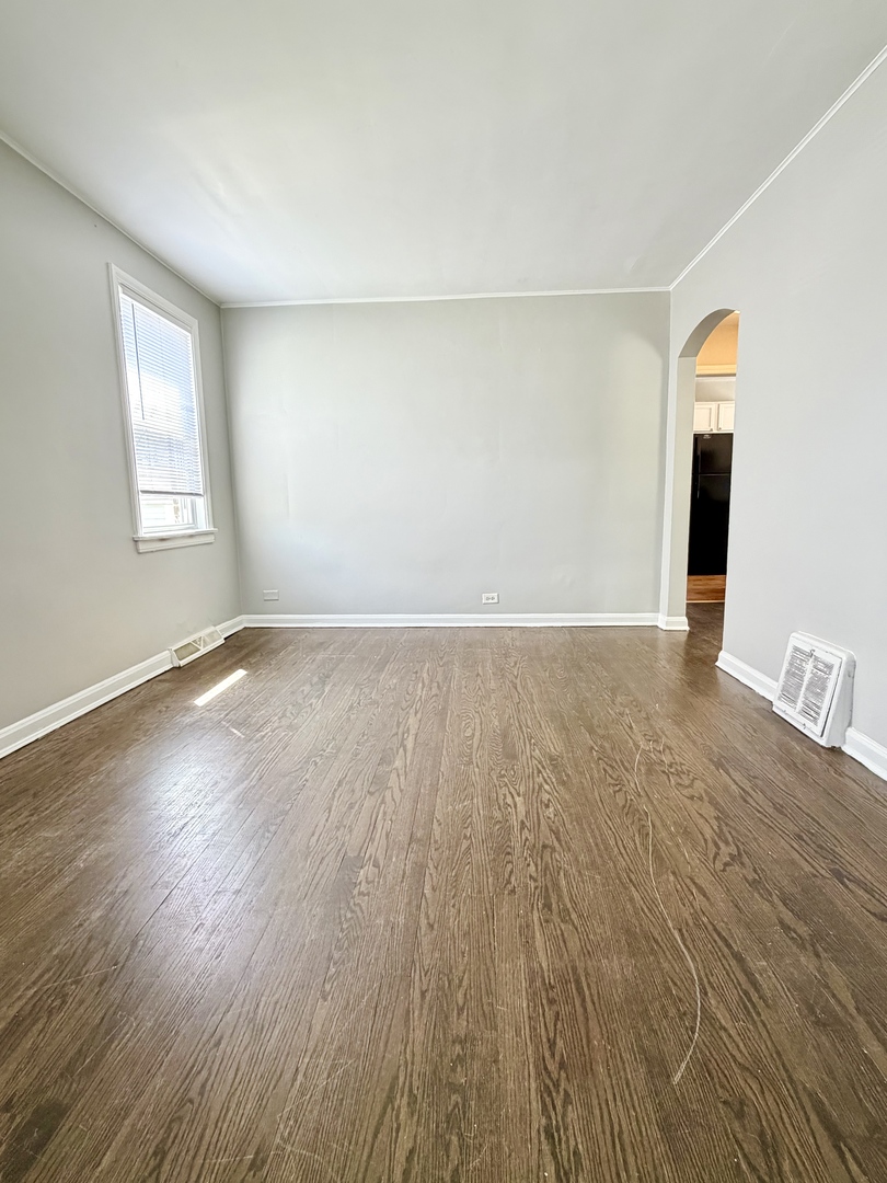 17826 School Street Lansing, IL 60438 - Photo 5 of 23 a view of an empty room with wooden floor and a window