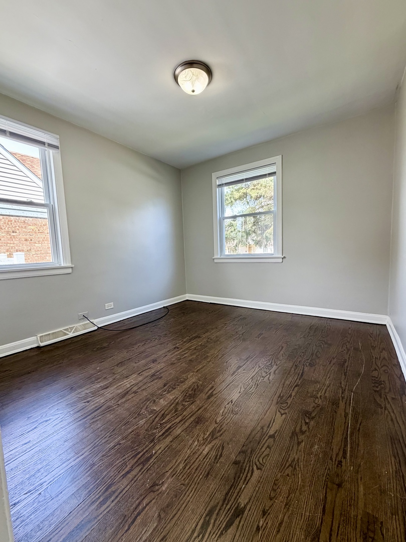 17826 School Street Lansing, IL 60438 - Photo 7 of 23 a view of an empty room with wooden floor and a window